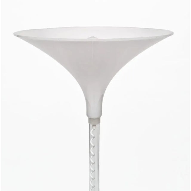 This 1980s floor lamp by Harco Loor showcases a stylish design with a perspex tube base and a round acrylic glass foot....