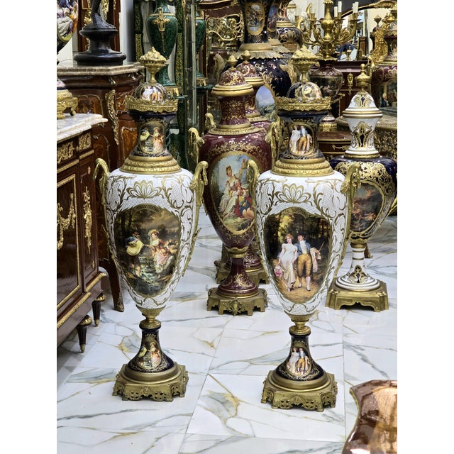 Elegant pair of French porcelain vases, decorated with a multicolored background and delicate galant scenes in reserve....