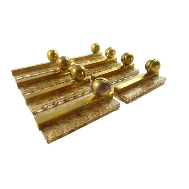 A set of eight vintage knife rests comprised of woven cane encased in Lucite and finished with brass accents, evoking the...