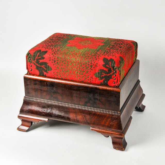 Stunning sculptural antique footstool. Mahogany base with red and green woven tapestry upholstered top. Base appears to be...