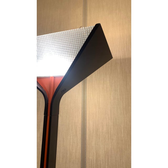 The object in the image is a floor lamp design by flos- papillona. The base is square and flat in metal. the body of the...