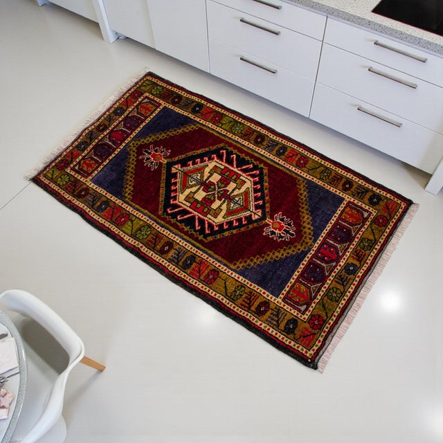 Vintage Turkish hand-knotted small rug from Tashpinar, Central Anatolia, 1970, featuring warm ruby red tones and authentic...