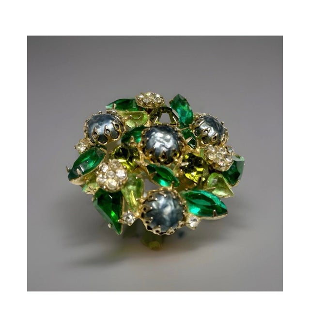 This decorative brooch was created in the mid-20th century by the American jewelry company DeLizza & Elster, commonly...