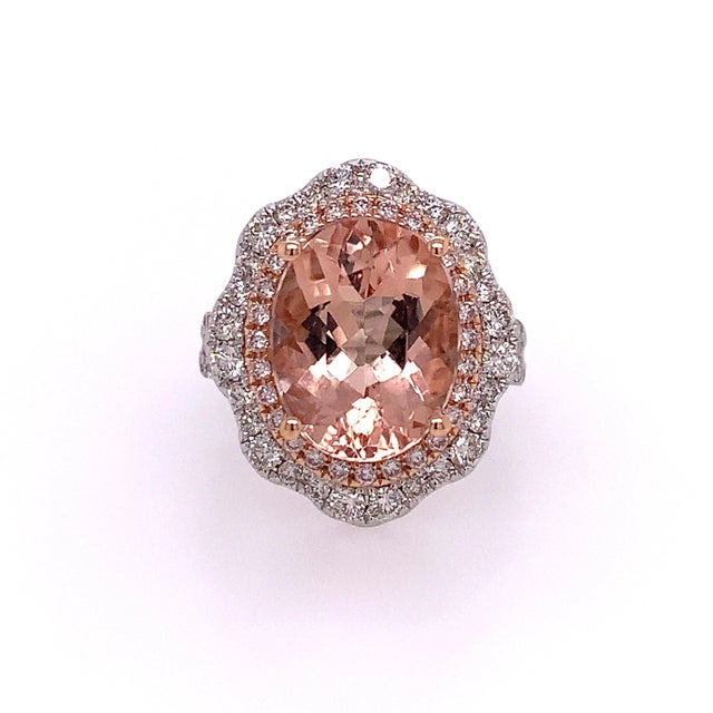 Make a statement with this exquisite 5.51-carat oval-cut Morganite and Diamond Halo Ring, a perfect blend of vintage...