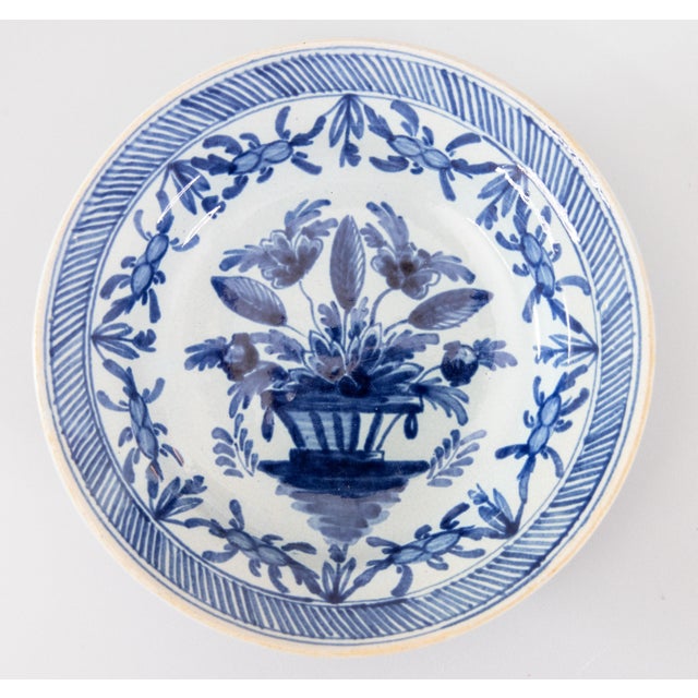 A rare pair of diminutive 18th-Century Dutch Delft faience floral plates by The Porceleyne Lampetkan. Maker's mark on...