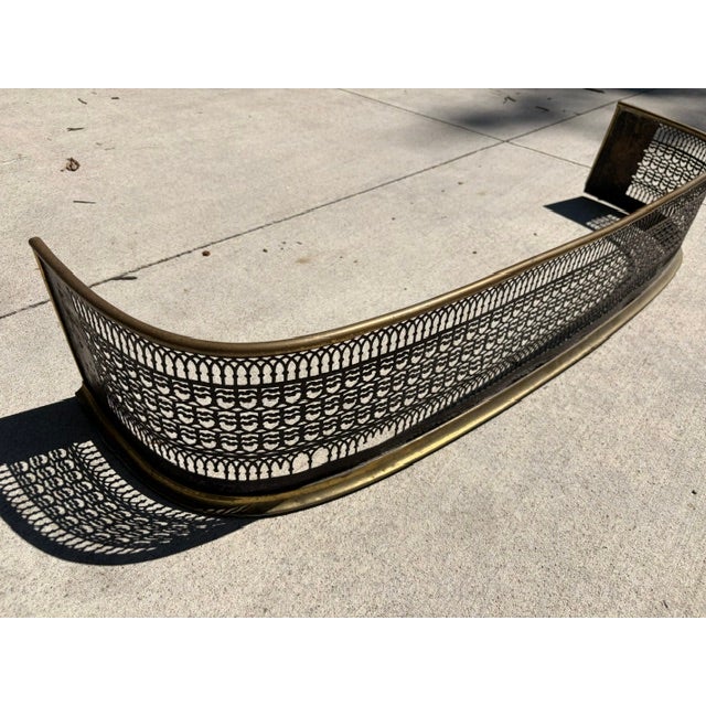 Antique pierced brass fireplace fender made in England during the 19th century. This high decorative piece features a...