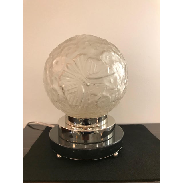 Pair of beautiful French Art Deco table lamps. The shades are enhanced by floral and butterfly motif in clear frosted...