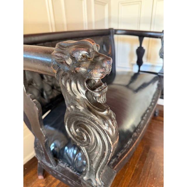 Beautiful and substantial 19th Century Victorian settee featuring hand-carved lion head arms, classical saber legs, and a...