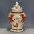 A charming Chinese porcelain covered jar featuring a creamy, all-over crackle glaze. The jar is decorated with iron-red...