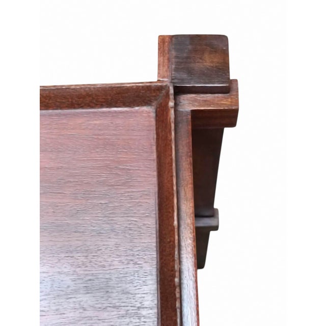 An elegant side table characterised by an architectural and geometric design crafted from fine wood. The supporting...