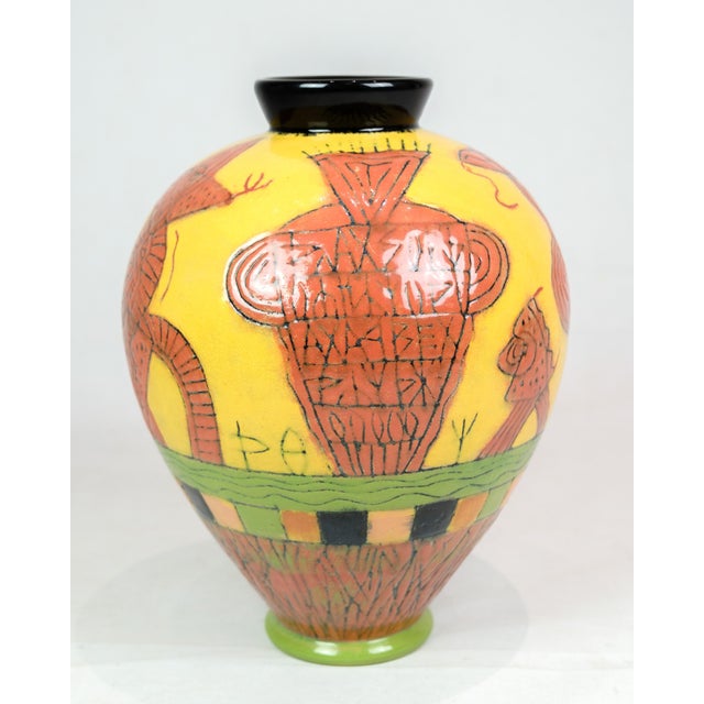 The vase, designed and hand painted by Lene Regius with yellow, orange and green glaze, is an artistic piece that bears...
