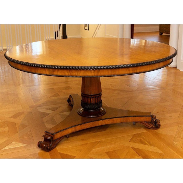 A large custom regency mahogany center hall or breakfast table with ebonized and carved beaded trim, a gradually tapered...