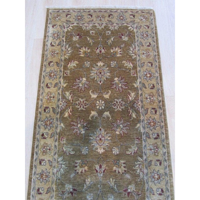 This hand knotted pile runner features a classic Sarouk style crafted from natural wool. Presented in a primary brown...