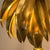 A dramatic 1970s French palm-shaped table lamp, crafted from brass and inspired by the Hollywood Regency style typical of...