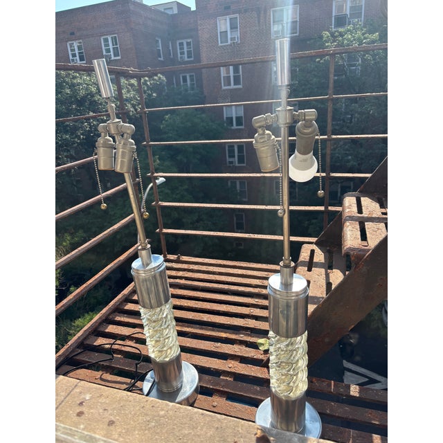 Pair of mid century glass and metal table lamps. The lamps showcase distinctive features from the 1960s to 1970s Space Age...