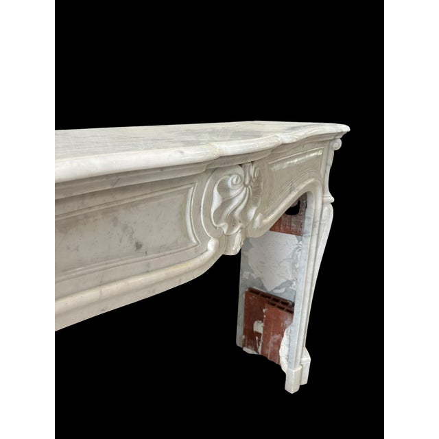 Late 19th-century carrara white marble fireplace. "three-shell" style. Recessed moldings on the lintel and jambs. Shaped...