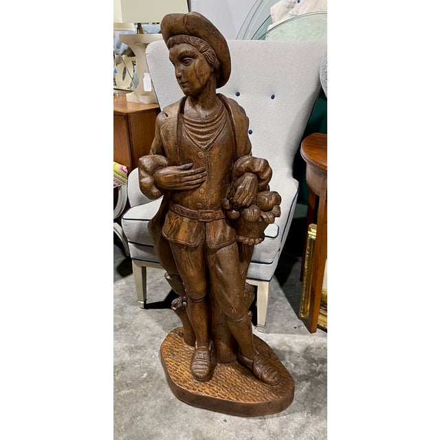 Statue of a young man hand carved from a solid piece of wood. Typically referred to as "Figure of Autumn" or a young man...