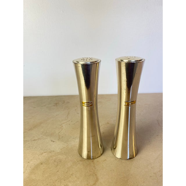 Sleek pair of vintage silverplate salt and pepper shakers in a sculptural hourglass silhouette, with concave tapered sides...