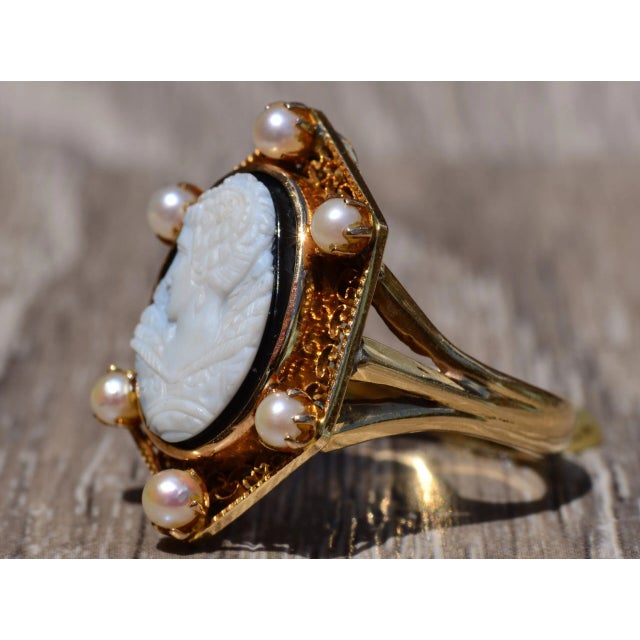 The Harper Antique Filigree Cameo Ring finished with six Pearls surrounding the center. The center is a hand carved cameo....