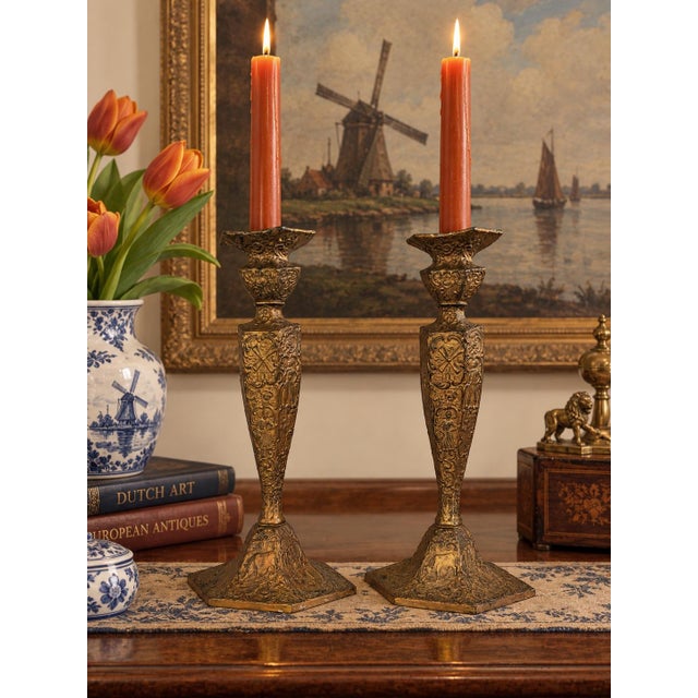 Antique pair of highly decorative E. & J. Bass candlesticks featuring richly embossed Dutch-inspired scenes and elaborate...