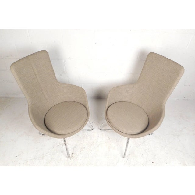 This gorgeous pair of contemporary modern lounge chairs feature unique metal rod bases with hairpin style feet. Unique...
