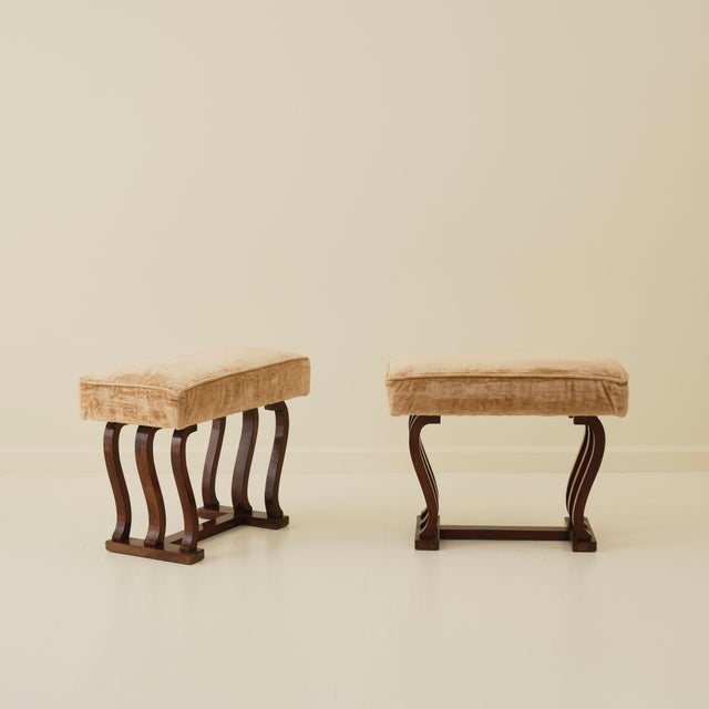 Pair of Italian Art Deco Stools, circa 1940's, featuring sculptural curved solid-wood legs and a rectangular upholstered...