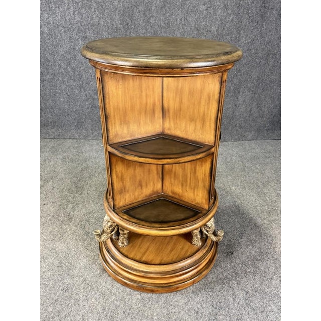This distinctive rotating library table features a circular design with tiered open shelving, finished in warm wood tones,...
