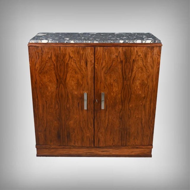 This Art Deco sideboard immediately captivates with its silhouette and the harmony of its materials. The body of the...