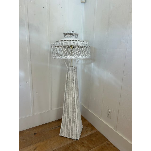Vintage floor lamp with woven wicker construction in white finish. Features a tall tapered base and tiered dome shade with...