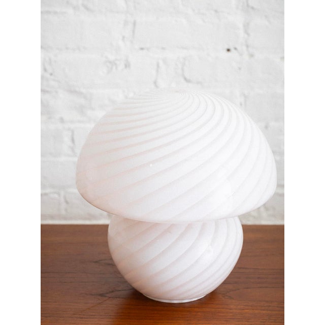 Glass mushroom lamp from Vetri Murano. Design features a continuous swirl pattern. Lamp appears mostly white when turned...
