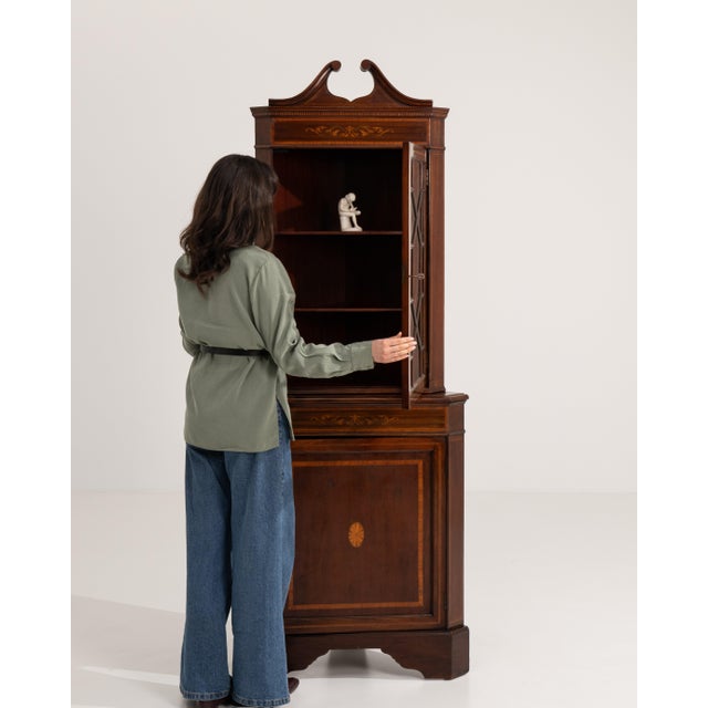A refined Georgian corner vitrine crafted in rich mahogany, designed to maximize space while providing elegant display...