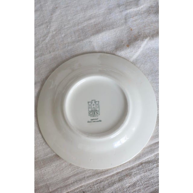 Elegant Gien teacup in ivory earthenware, decorated with a deep blue bouquet and a slight relief near the rim. The curved...