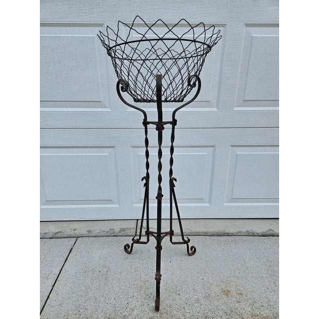This garden plant stand is 39.75 inches in height and has a tripod base. The base has several floral accents with a hint...