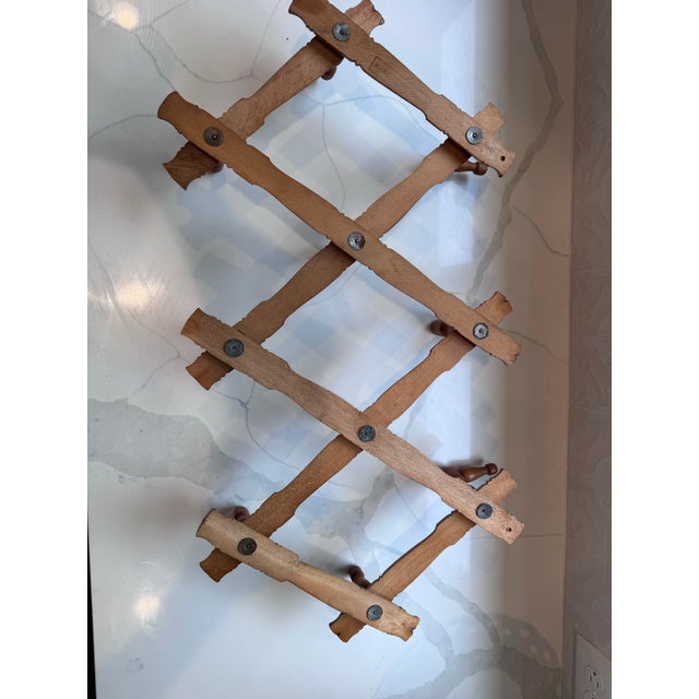 A handsome vintage accordion peg rack made in Bulgaria, featuring turned wood pegs shaped in a faux-bamboo style and a...