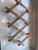 A handsome vintage accordion peg rack made in Bulgaria, featuring turned wood pegs shaped in a faux-bamboo style and a...