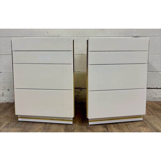 This is a gorgeous and rare pair of vintage 1980s Bridgeford Via Veneto ivory lacquered nightstands or side tables. They...