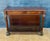 Elegant Empire Revival console table crafted in wood with richly figured burl veneer accents, dating to the mid 20th...