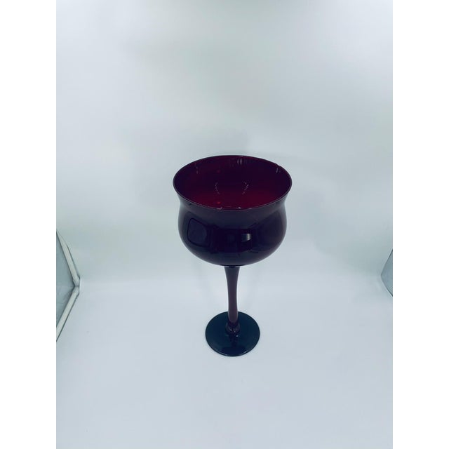 A large, decorative vintage-style goblet made of high-quality glass. The deep ruby-colored goblet features a wide, tulip-...
