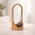 Bring a glow of natural elegance to your space with this arched wood hurricane candle holder, blending rustic wood grain...