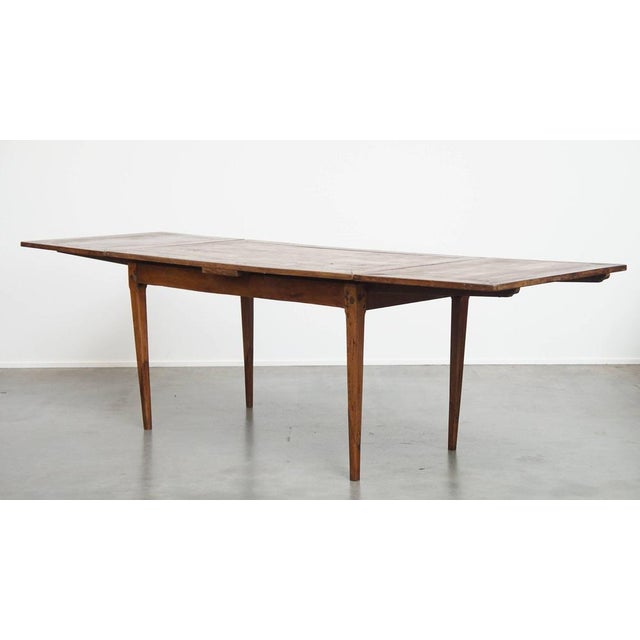 Offered is this functional and beautiful English antique elm and cherry extendable dining table. A great antique dining...