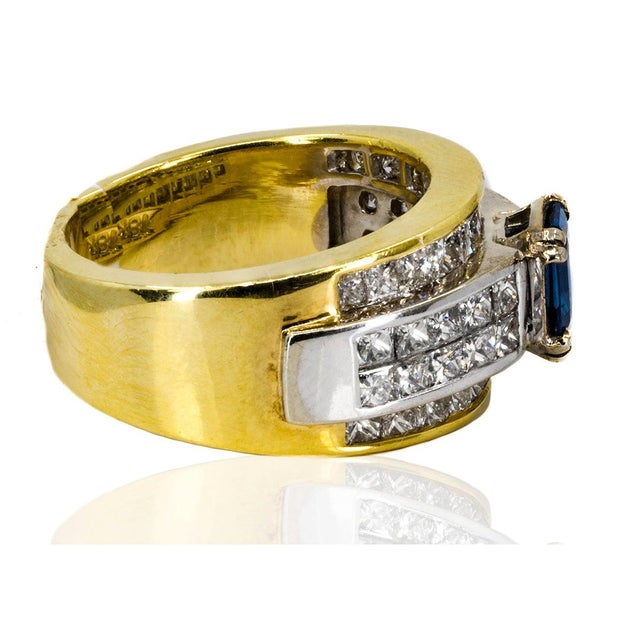 14K two tone gold ring with one emerald cut sapphire weighing 1.05 carats and 30 princess cut diamonds weighing 3.06...