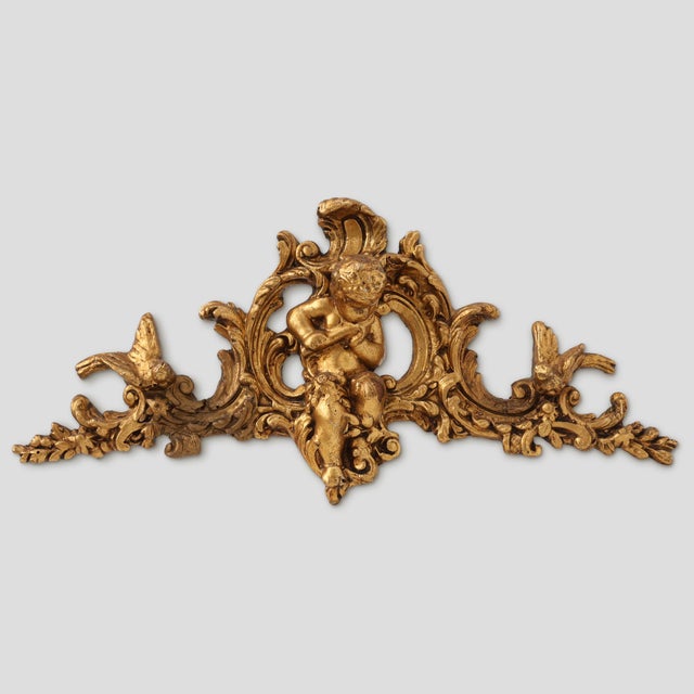 An exquisite French Louis XV giltwood ornament from the 18th century, richly carved in the Rococo style. The composition...