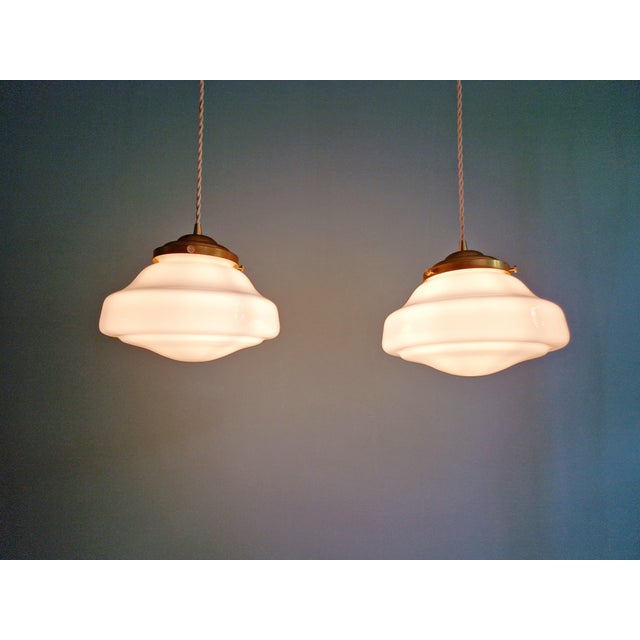 Pair of Art Deco pendant lights with two white opaline glass globes, 1930s. Each light has been restored and is compatible...