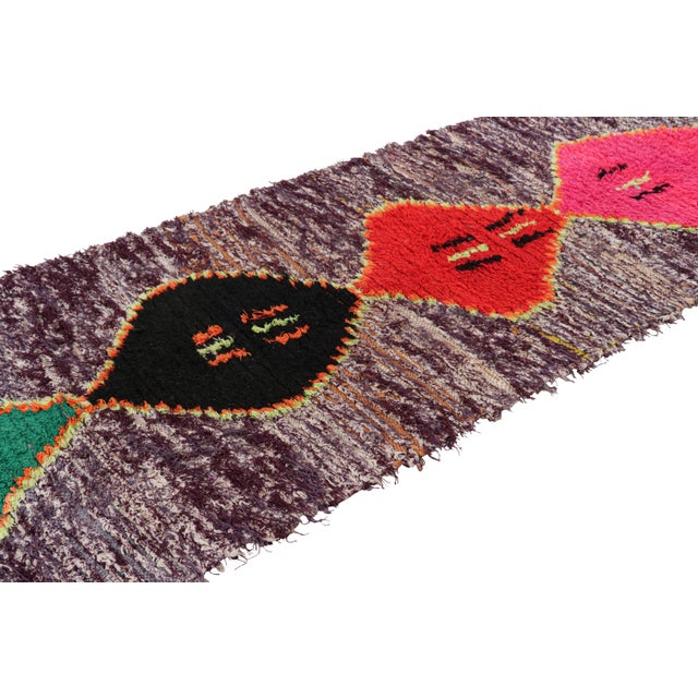 Hand-knotted in wool and originating from Morocco circa 1950-1960, this 4x9 vintage Moroccan rug is an extremely rare...