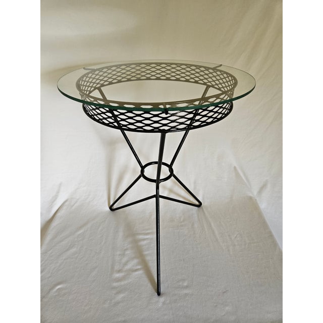 An MCM Atomic Tripod Hairpin Wrought Iron and Glass Side Table, Featuring great retro styling on a sturdy table with...