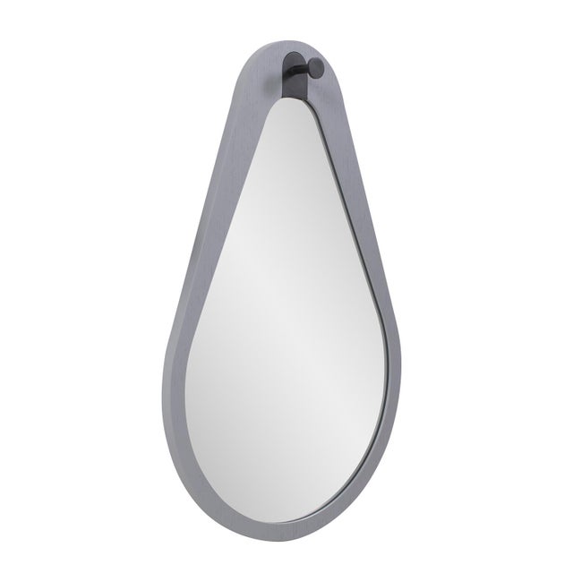 Its irregular shape creates visual interest, while the light grey matte frame exudes an air of sophistication and subtle...
