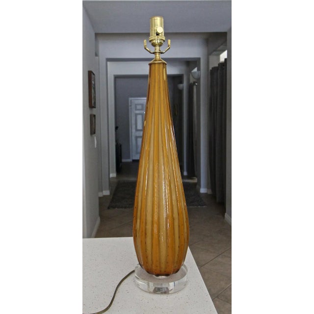 Murano ribbed orange colored glass table lamp with controlled bubbles. The ribbed glass gives the lamp alternating shades...