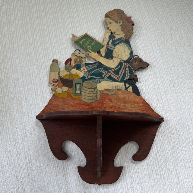 Absolutely charming vintage wooden wall shelf featuring a whimsical hand painted scene of a young girl baking with a...