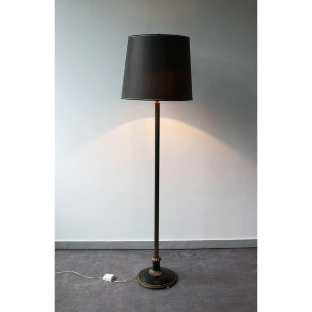 Bronze floor lamp composed of an elegantly tapered base resting on a forest green lacquered metal base and bronze details....