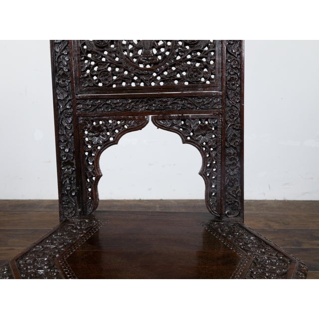 An Anglo-Indian accent side chair circa 1900 with abundant and richly hand-carved floral motifs, scrolling foliage,...